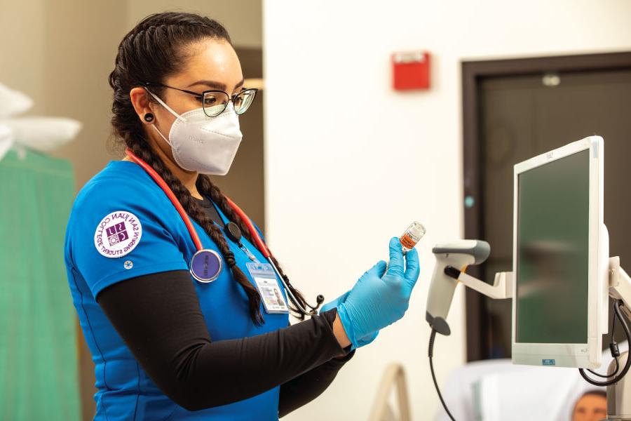 A San Juan College student learning medical equipment at the School of Health Sciences